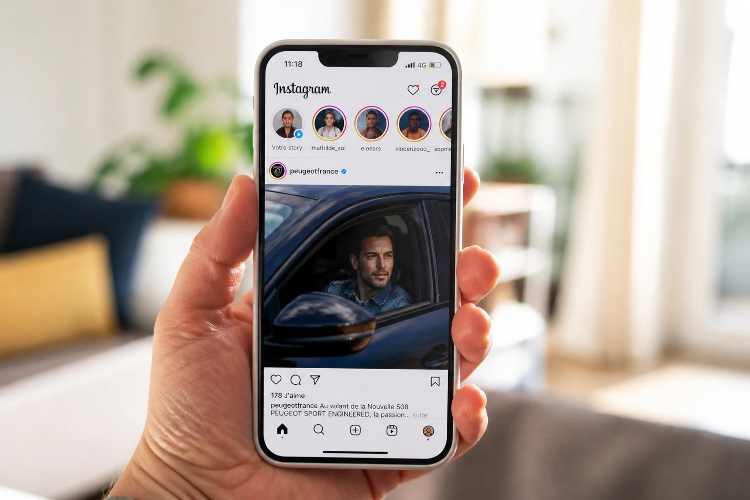 Smartphone affichant des stories Instagram sur fond de salon lumineux