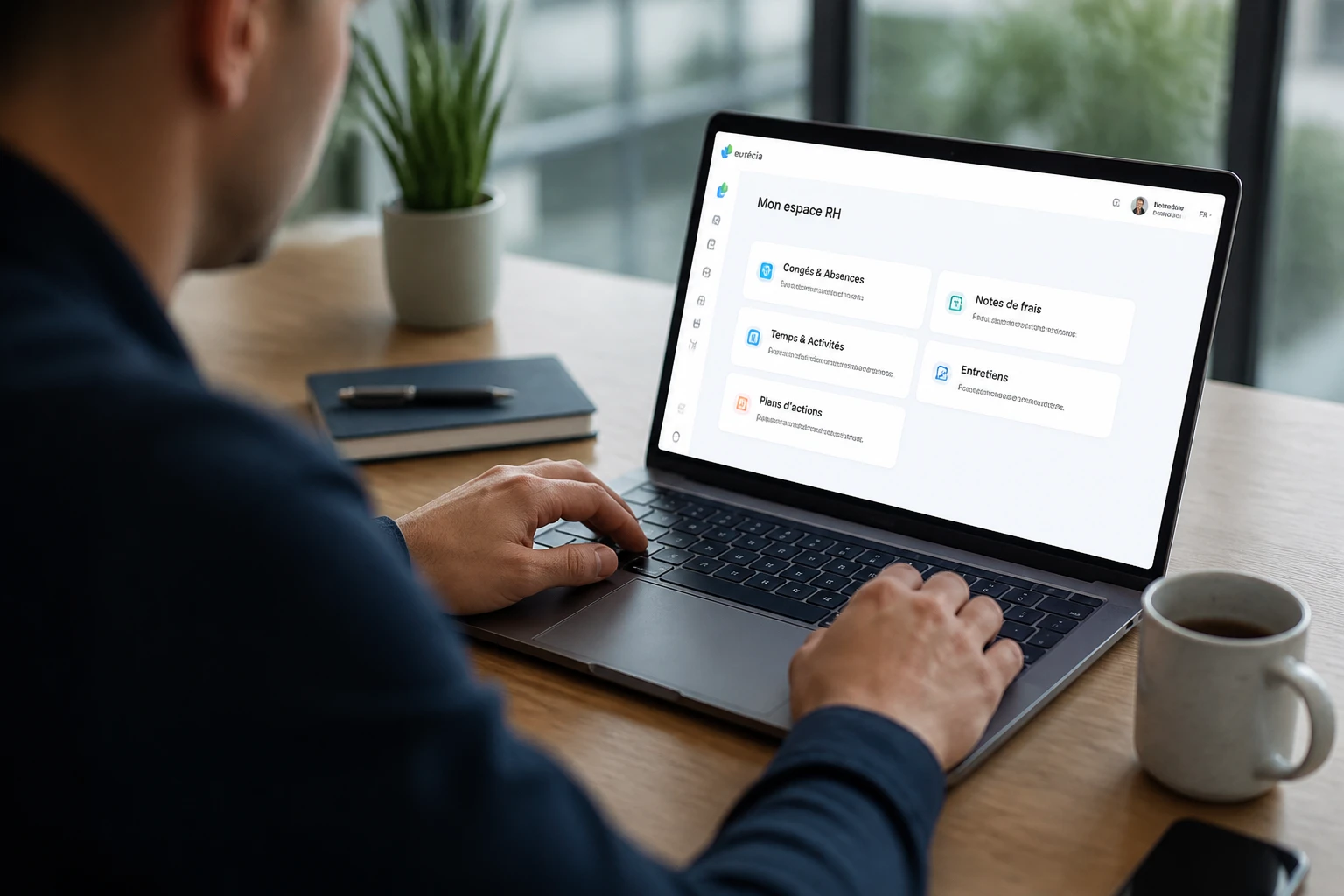 Salarié consultant son espace RH en ligne sur ordinateur portable dans un bureau lumineux